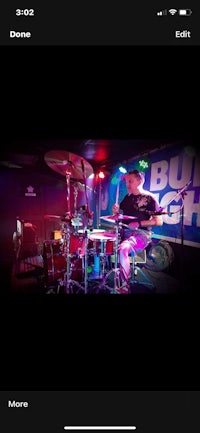 a man is playing drums on stage in front of a crowd