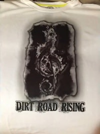 a t - shirt with the words dirt road rising on it